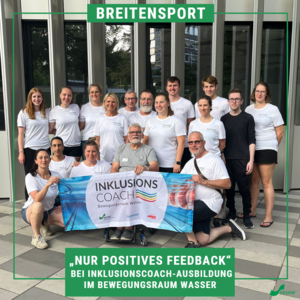 Das Bild zeigt das Gruppenfoto der Teilnehmer*innen der ersten Inklusionscoach-Ausbildung in Köln. Alle lächeln in die Kamera und halten das Banner in der Hand.